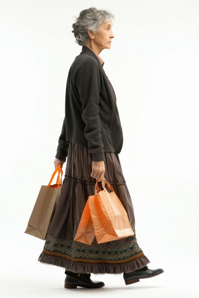 Full length profile shot of a mature woman carrying grocery bags footwear handbag walking.