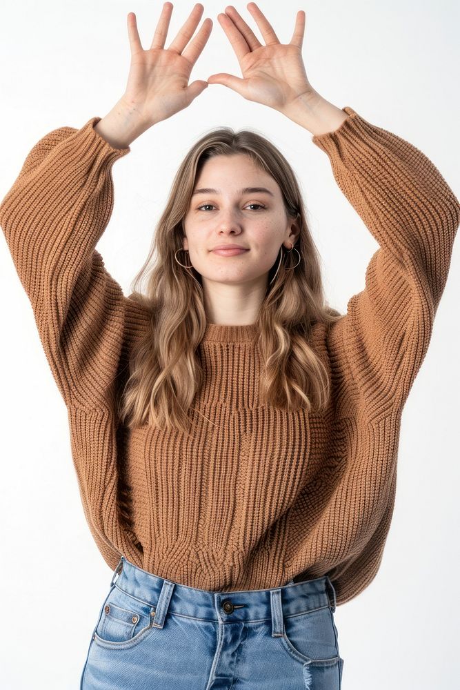 Caucacian young adult woman raising hands sweater sweatshirt hairstyle.