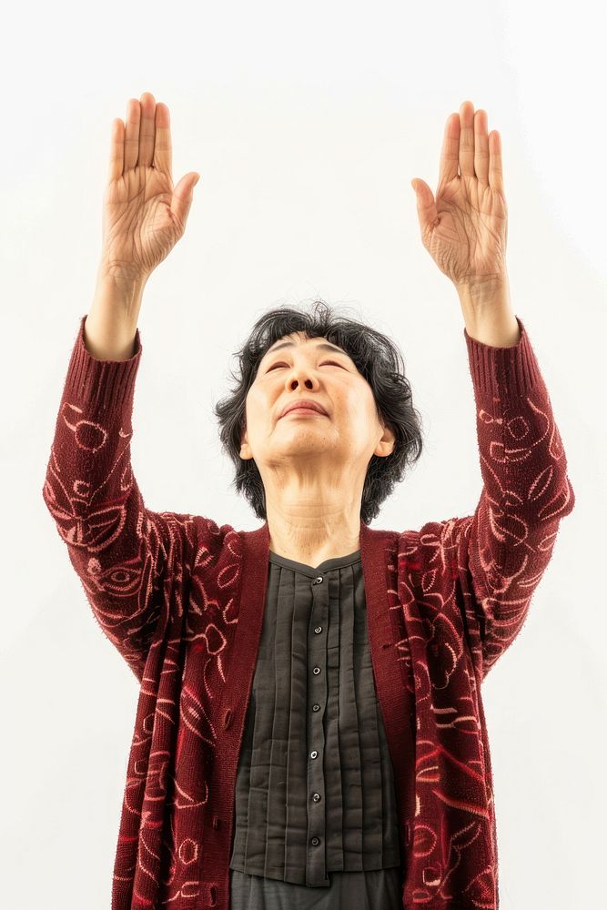 Japanese adult woman raising hands spirituality meditating gesturing.