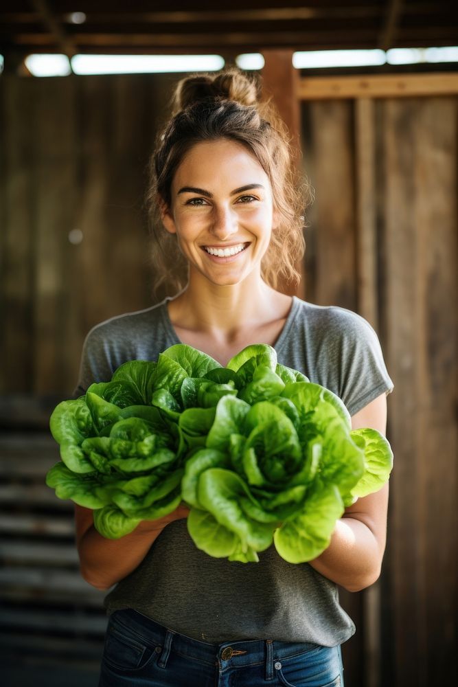 A happy woman holding fresh butter head lettuces vegetable produce female.