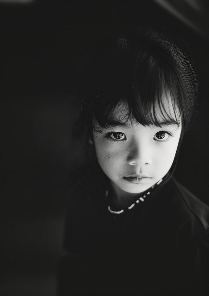 Analog black and white film photography of an asian kid accessories accessory portrait.