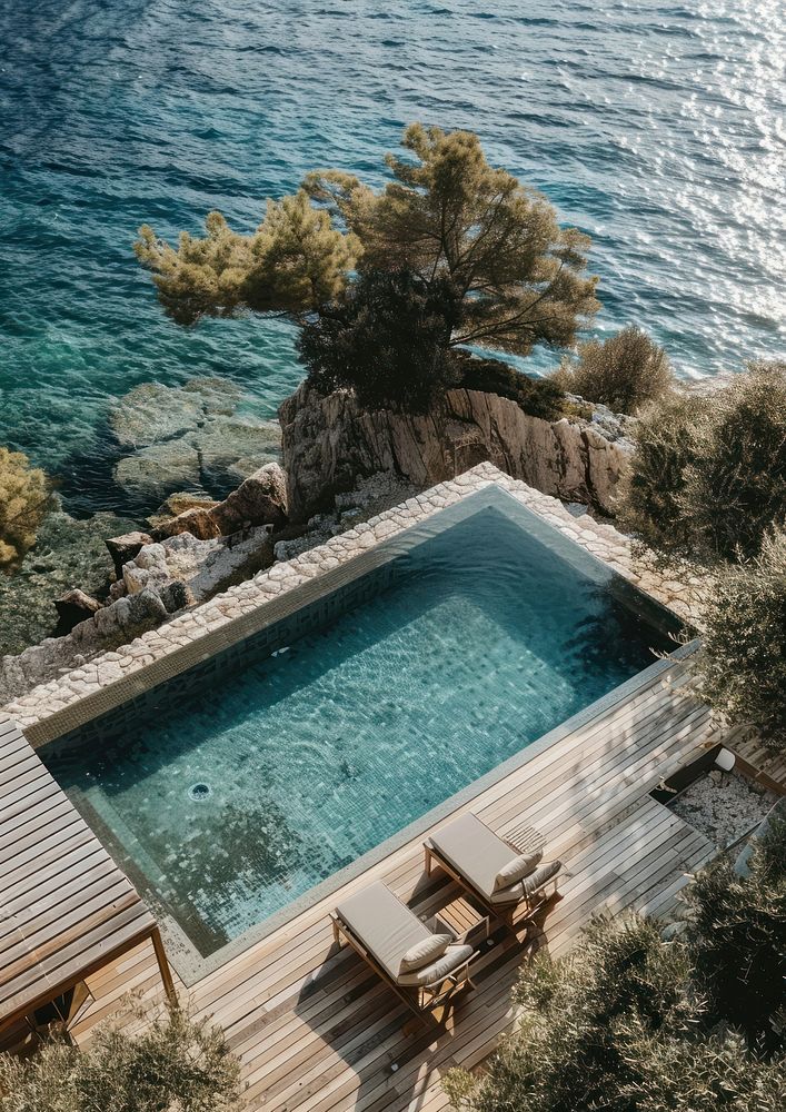 Minimalistic hotel pool outdoors sea furniture.
