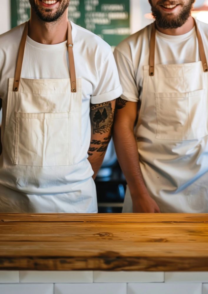 2 men wearing white fabric apron clothing apparel person.