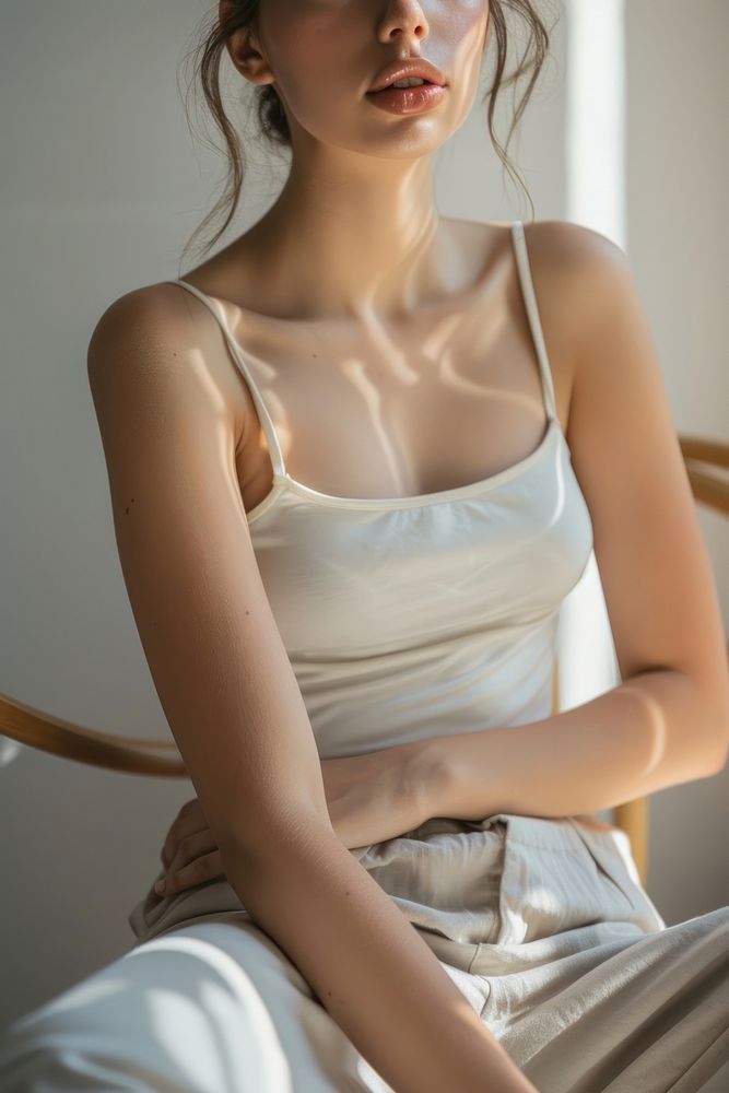 Detail of woman gentle skin in color pastel color tank top sitting adult contemplation.