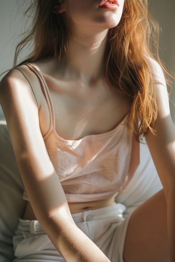 Detail of woman gentle skin in color pastel color tank top adult contemplation undergarment.