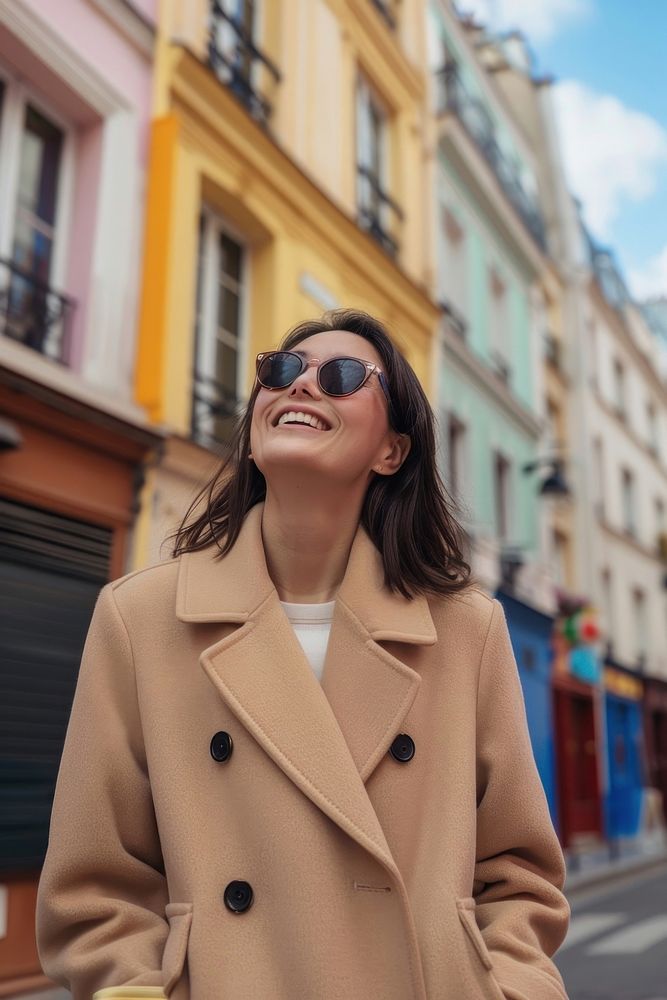 A happy woman with sunglasses and beige coat with baguette in arms street adult architecture.