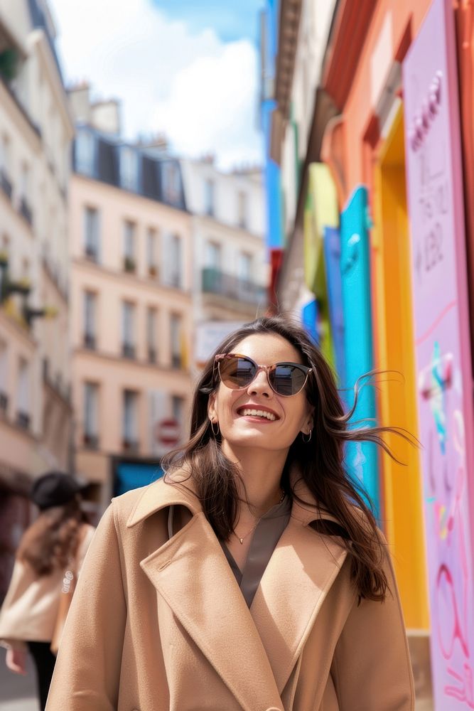 A happy woman with sunglasses and beige coat with baguette in arms walking street adult.