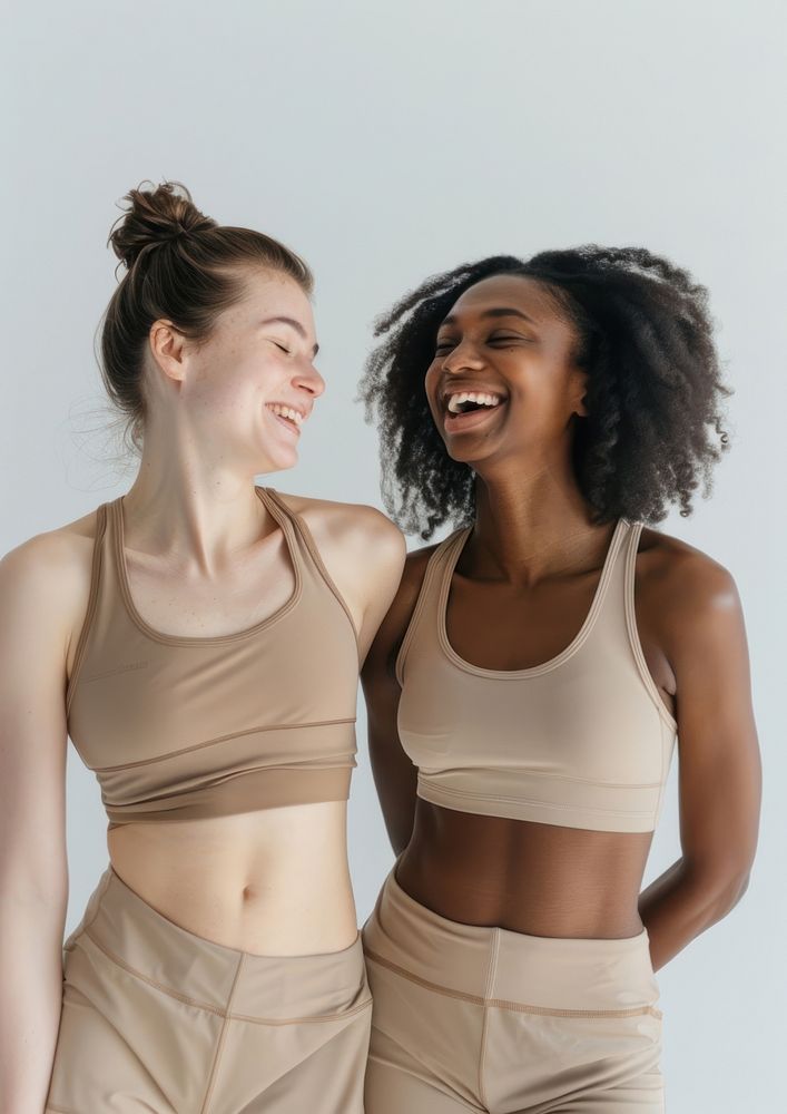 2 women wearing earth tone color sport wear happy laughing clothing.