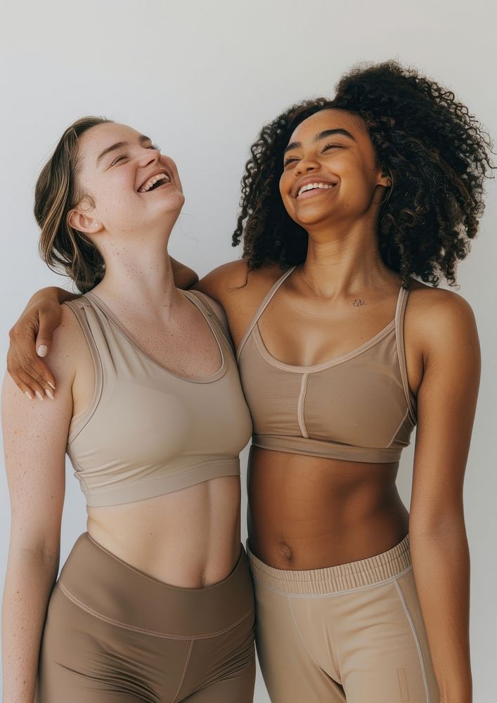 2 women wearing earth tone color sport wear happy laughing person.