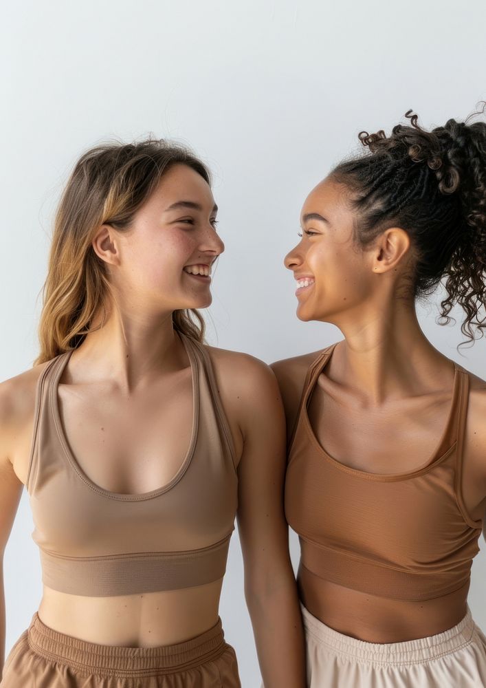2 women wearing earth tone color sport wear happy laughing clothing.