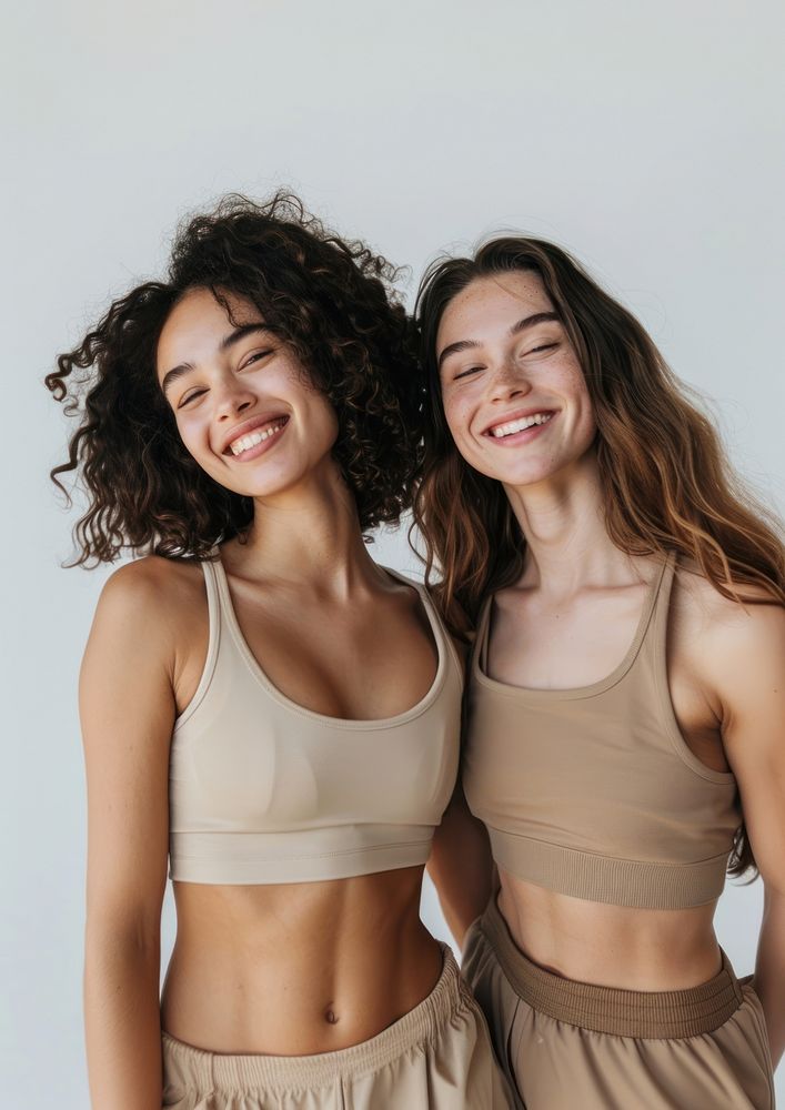 2 women wearing earth tone color sport wear happy laughing person.