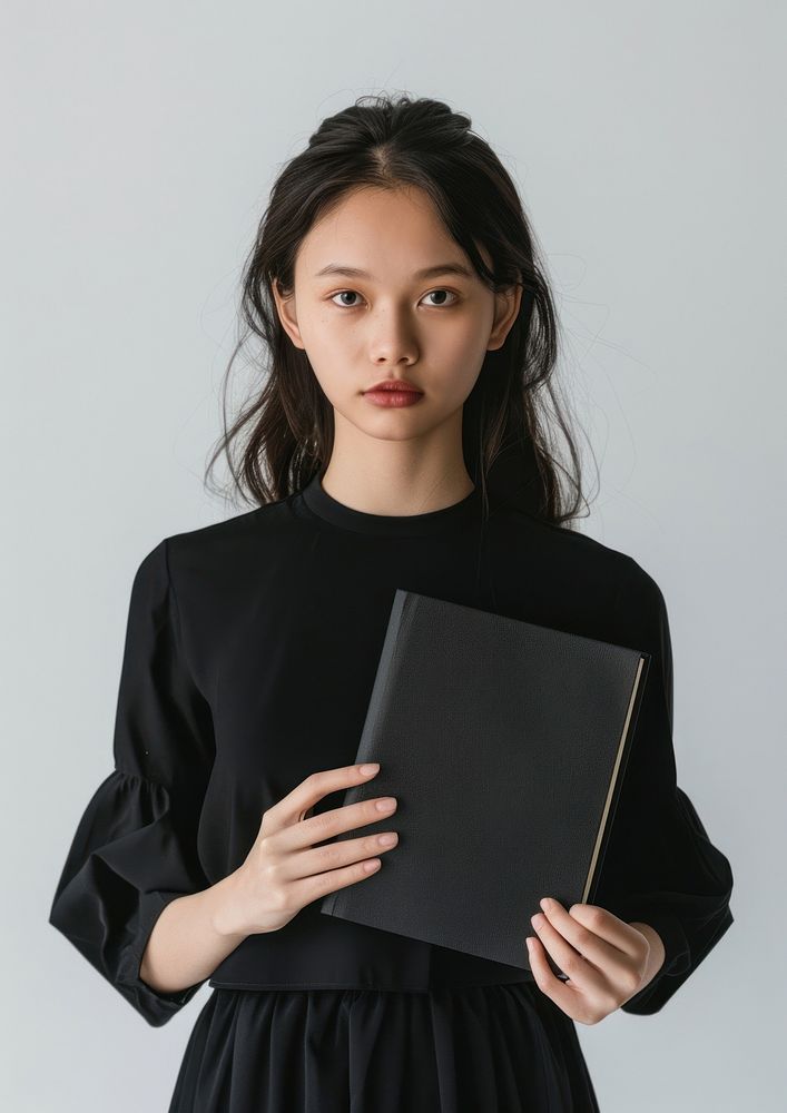 Holding a sleek black mini notebook photo photography clothing.