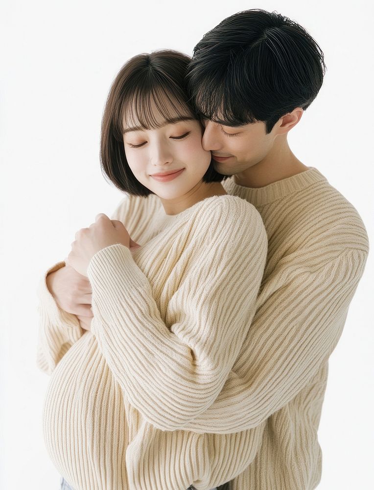 Asian happy pregnant woman being embraced by her caucasian blue eye husband sweaters hug affection.