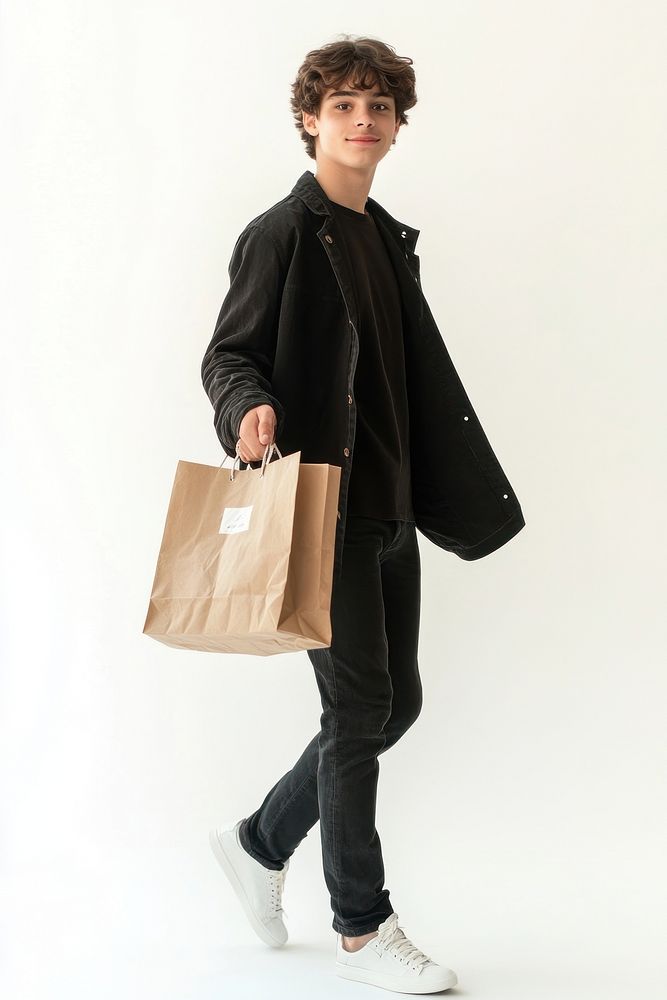 Young teenager man shopping walking smiling.