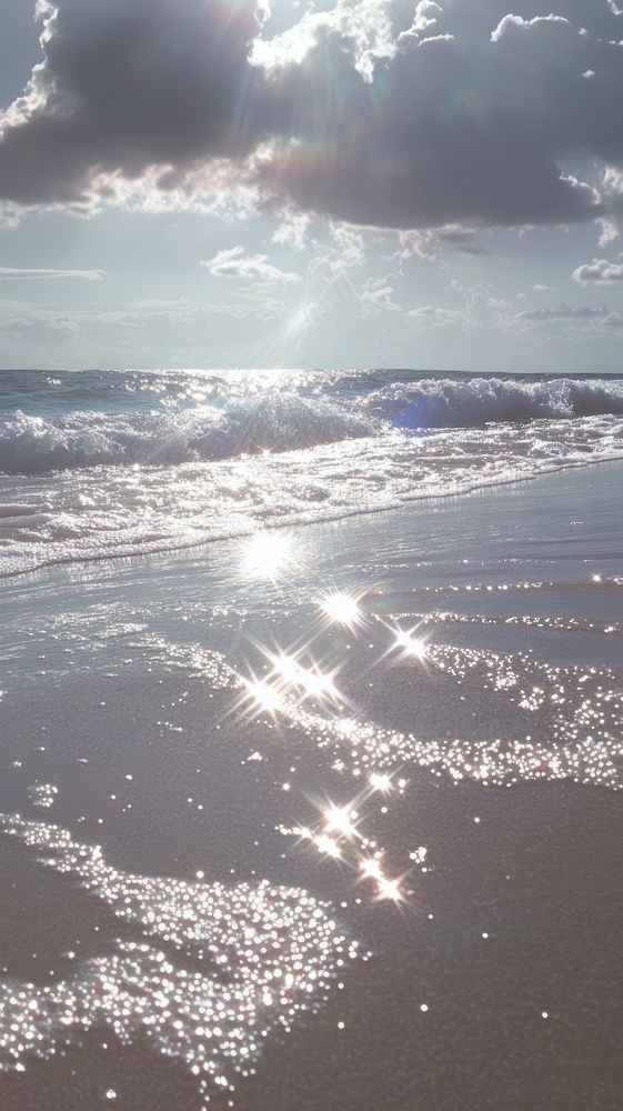 Beach sunlight clouds ocean.