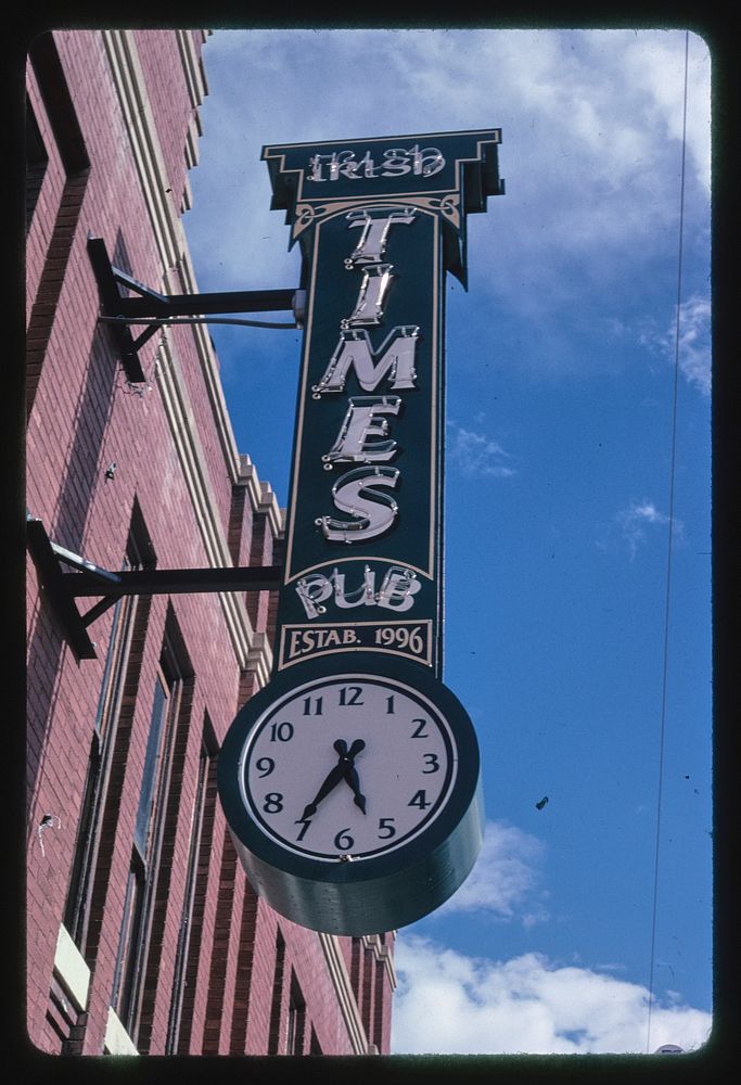 Irish Times Pub Clock-sign, Main Street, Butte, Montana (2004) photography in high resolution by John Margolies. Original…