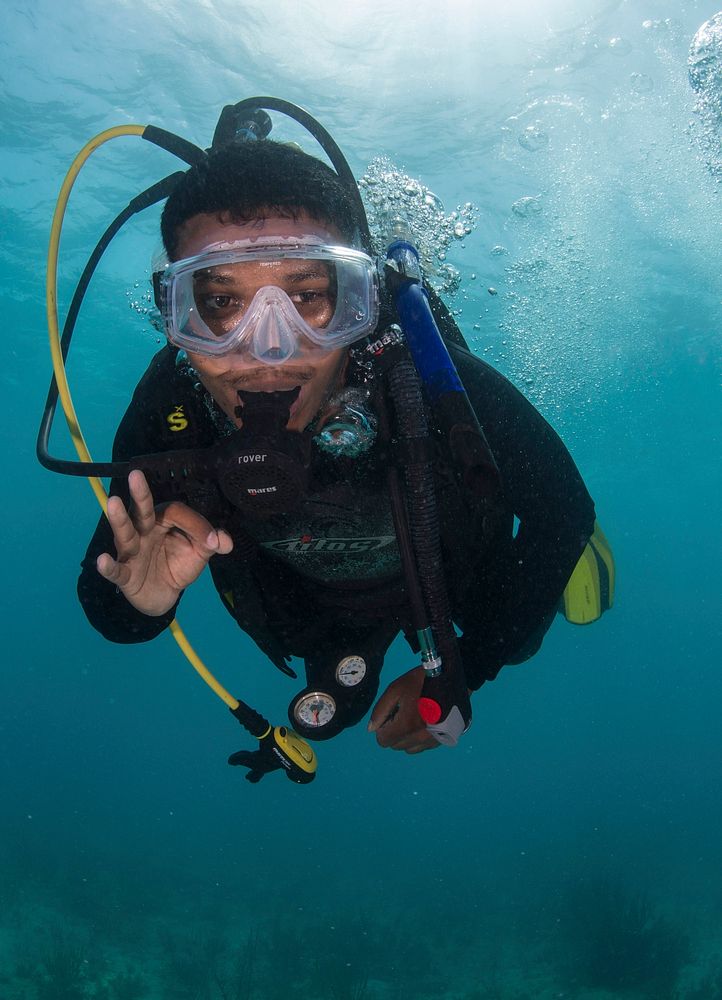Belize Defense Force Petty Officer 3rd Class Abraham Hinds signals the lead diver during a training dive with U.S. Sailors…