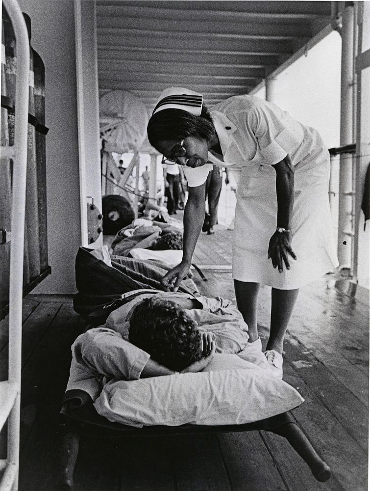 South China Sea. A Navy nurse aboard the hospital ship USS Repose (AH-0016) offers a word of encouragement to a patient who…