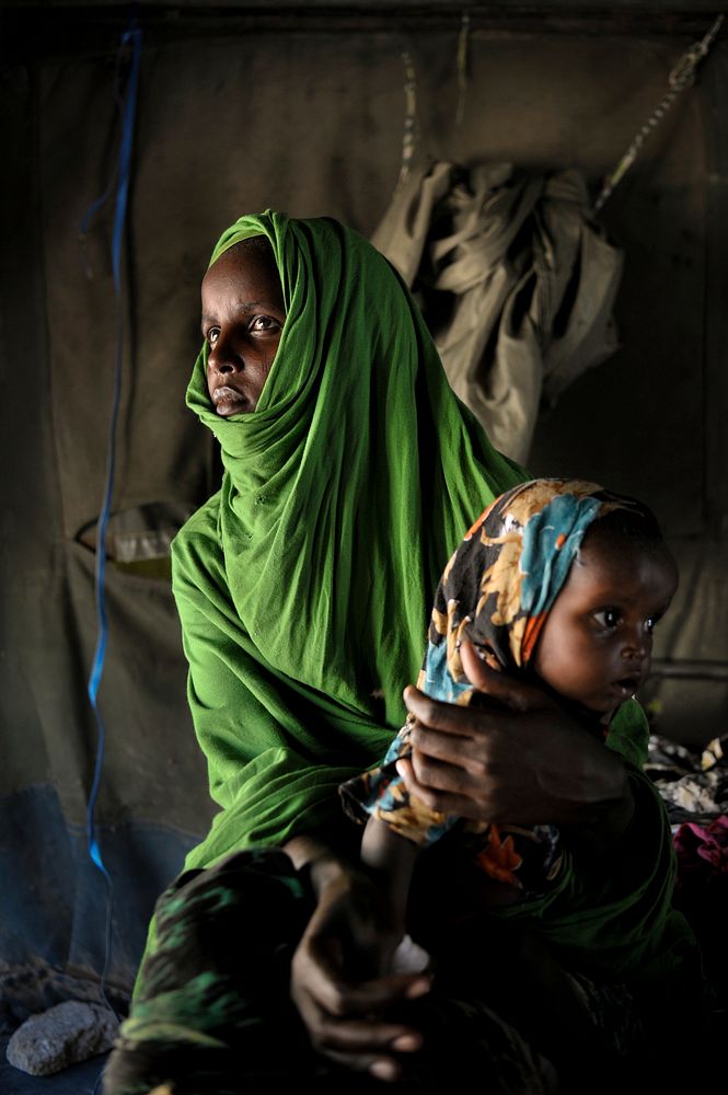 A mother holds her sick child in a Burundian-run clinic in the Somali capital, Mogadishu, on April 15. AU UN IST PHOTO /…
