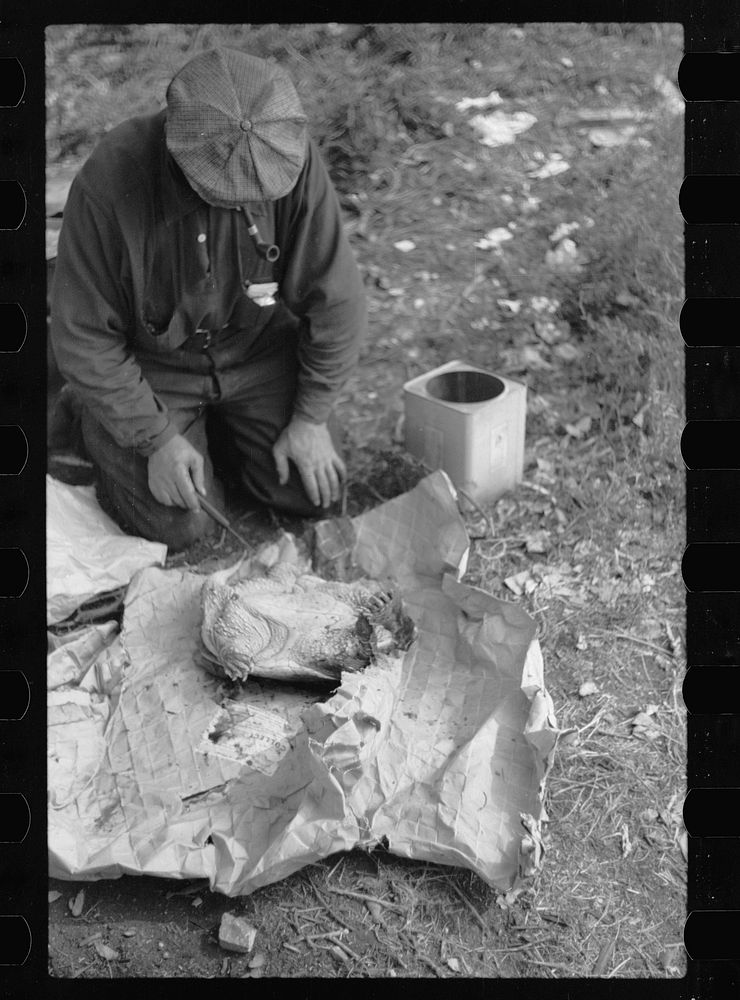 Man in hobo jungle killing turtle to make soup, Minneapolis, Minnesota. Sourced from the Library of Congress.
