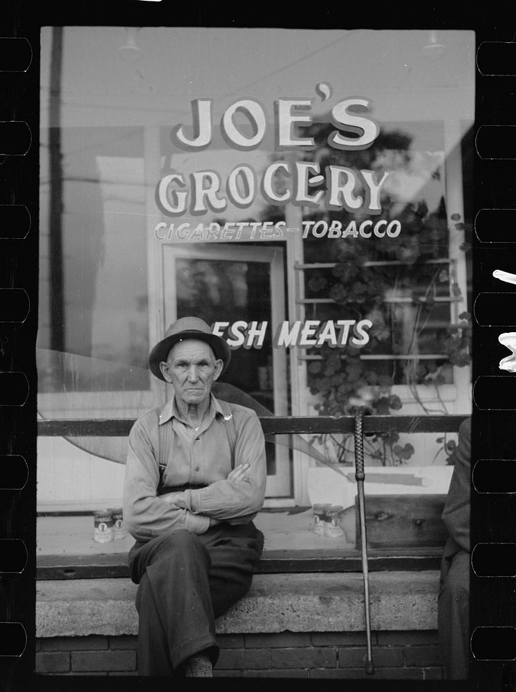 Man in front of grocery store, Elkins, West Virginia. Sourced from the Library of Congress.