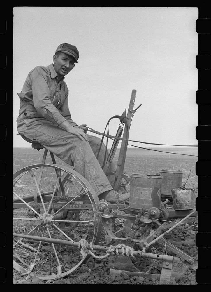 [Untitled photo, possibly related to: Adjusting the wire on corn planter, Monona County, Iowa]. Sourced from the Library of…