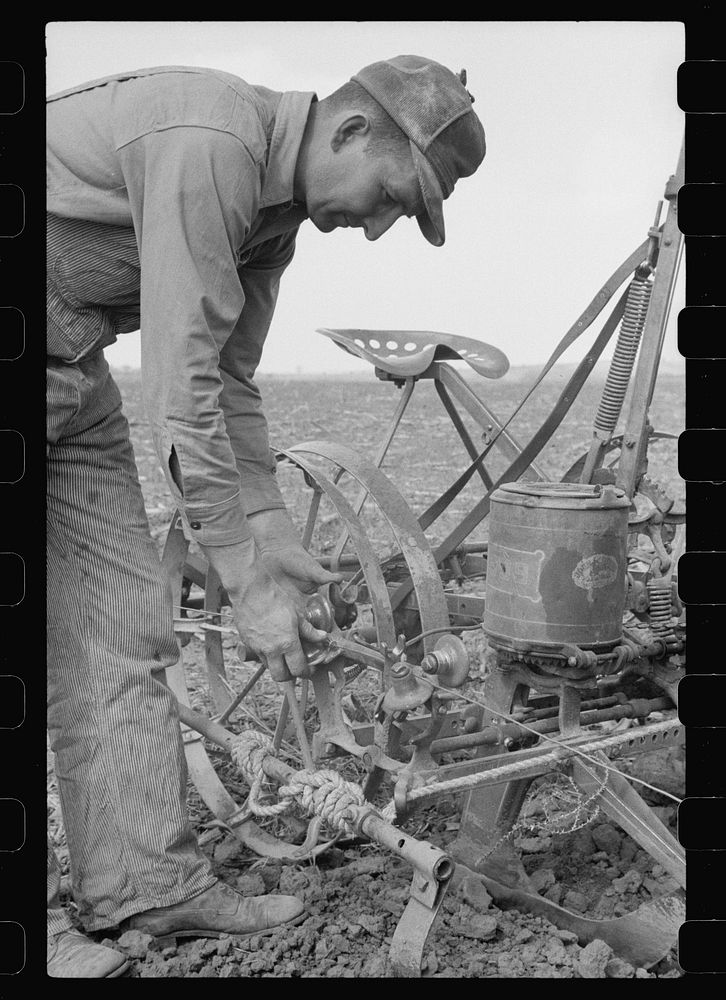 Adjusting the wire on corn planter, Monona County, Iowa. Sourced from the Library of Congress.