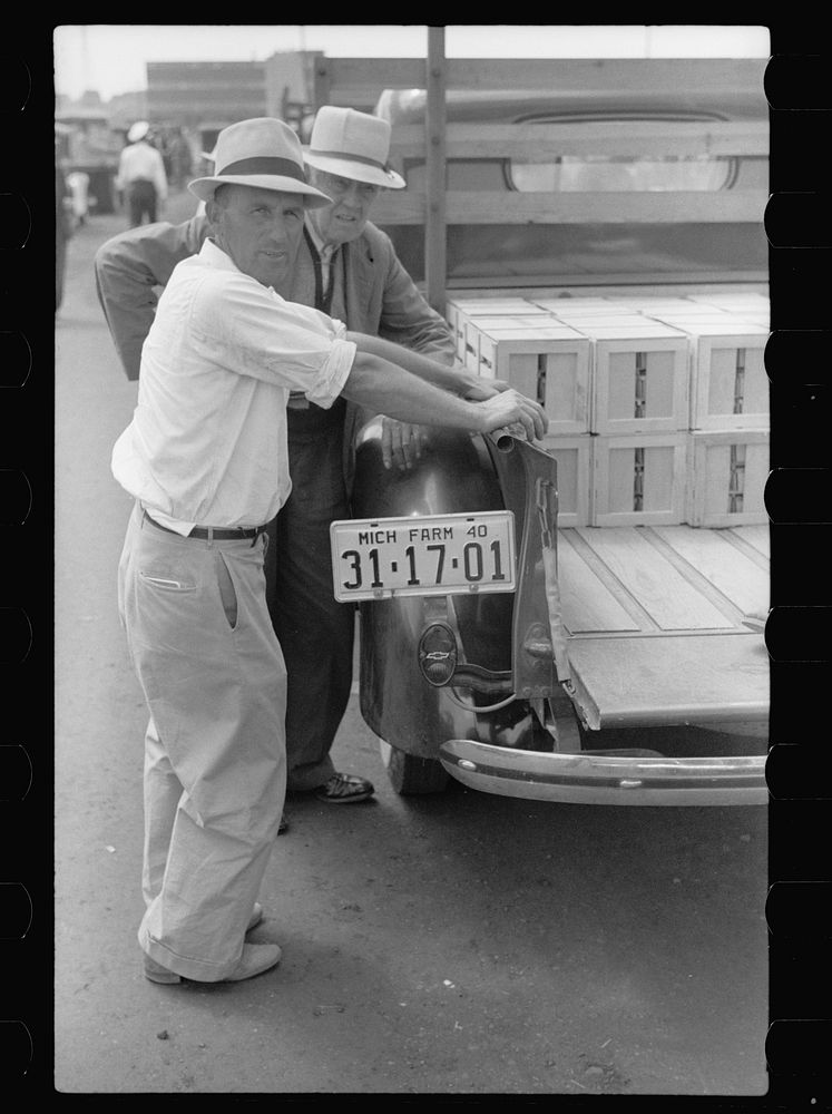 [Untitled photo, possibly related to: Buyer examining cherries in fruit market, Benton Harbor, Michigan]. Sourced from the…