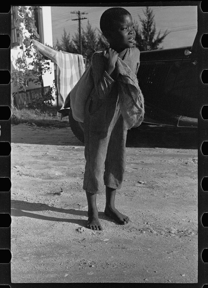 A  boy bringing away defective grapefruit from the Fort Pierce fruit canning plant, Florida. Sourced from the Library of…
