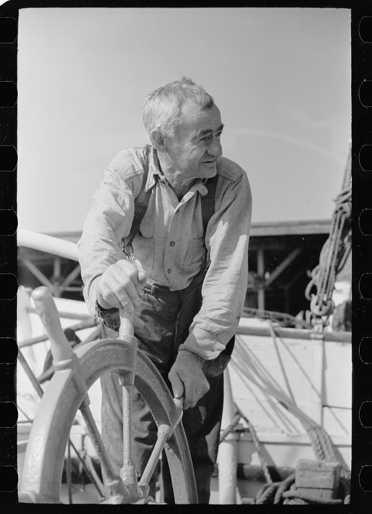 Oysterman at wheel of boat, Bivalve, New Jersey. Sourced from the Library of Congress.