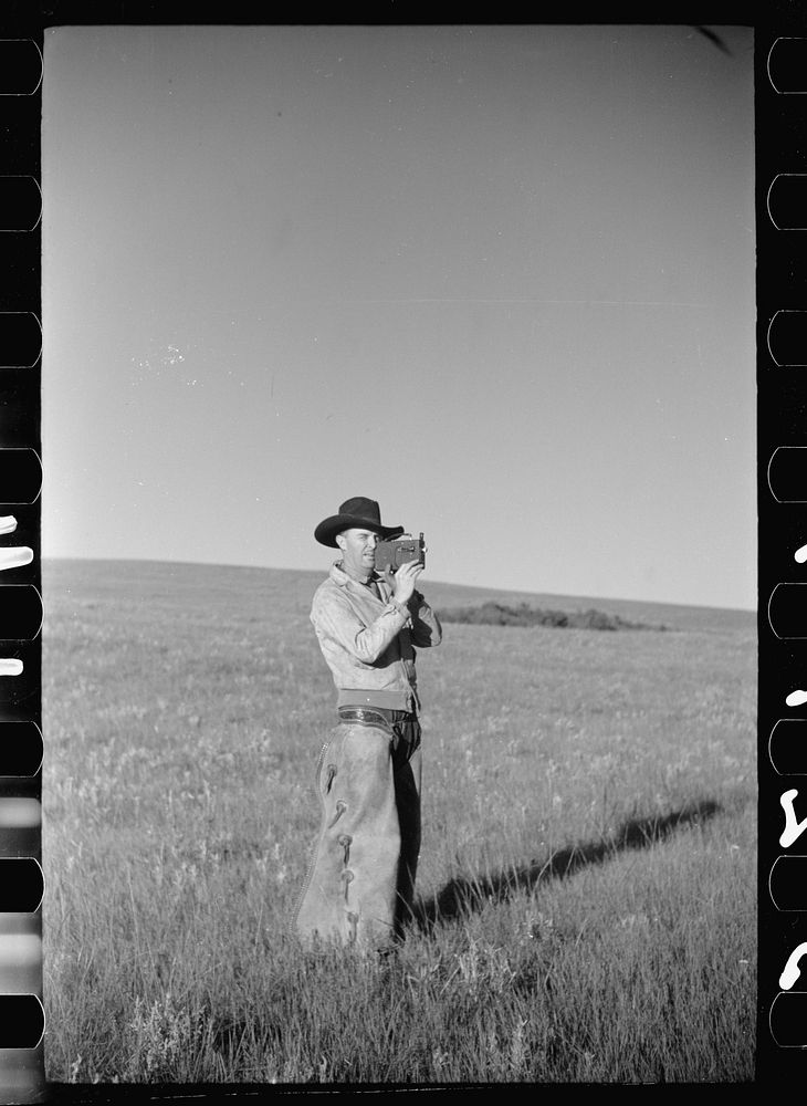 Cowboy with amateur movie camera, Quarter Circle U roundup, Montana. Sourced from the Library of Congress.