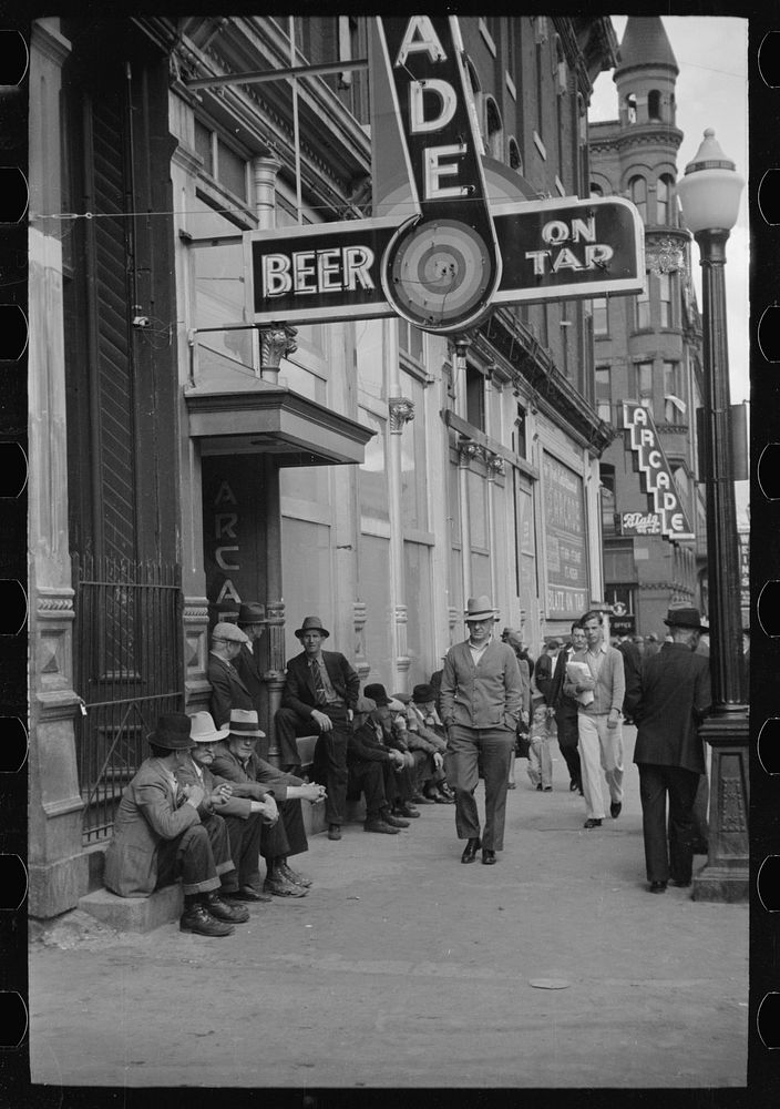 Men lounging in front of arcade, Butte, Montana. Sourced from the Library of Congress.