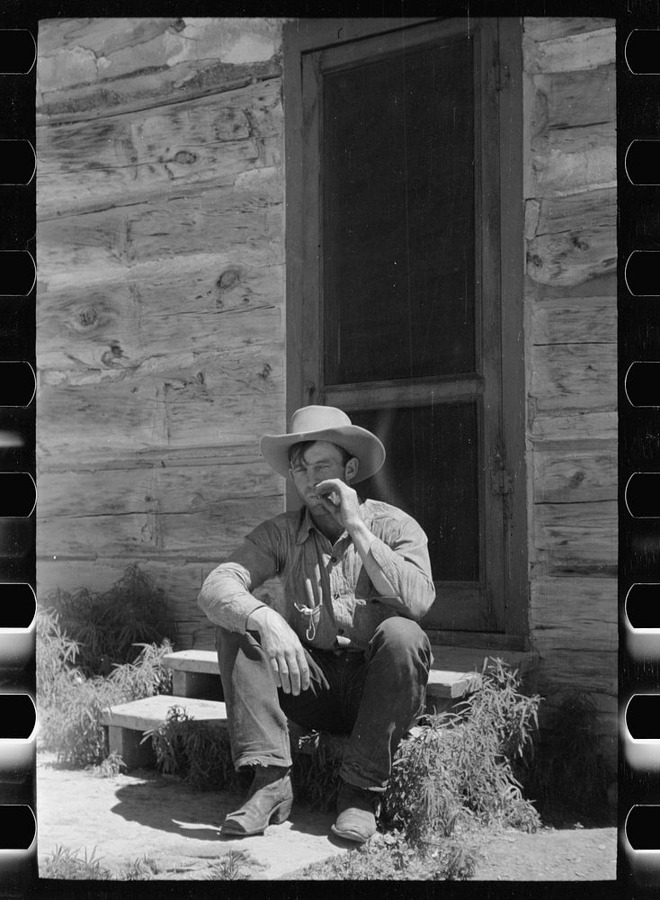 Cowboy in front of bunkhouse, Quarter Circle U Ranch, Big Horn County, Montana. Sourced from the Library of Congress.