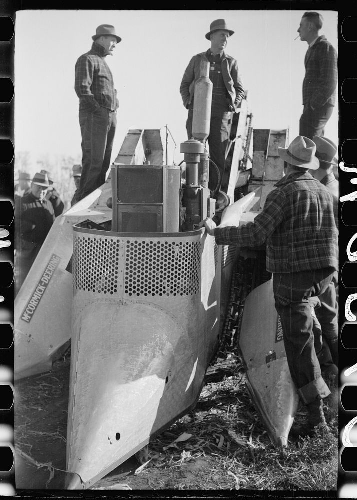 [Untitled photo, possibly related to: Farmers examine a two-row mounted corn picker, mechanical cornhusking contest, Hardin…