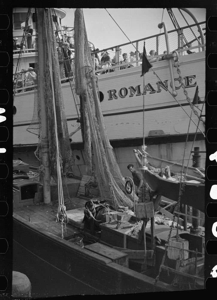 The economy of a town: fishing and the tourist trade. A fishing boat in front of the S.S. "Romance," a tourist boat which…