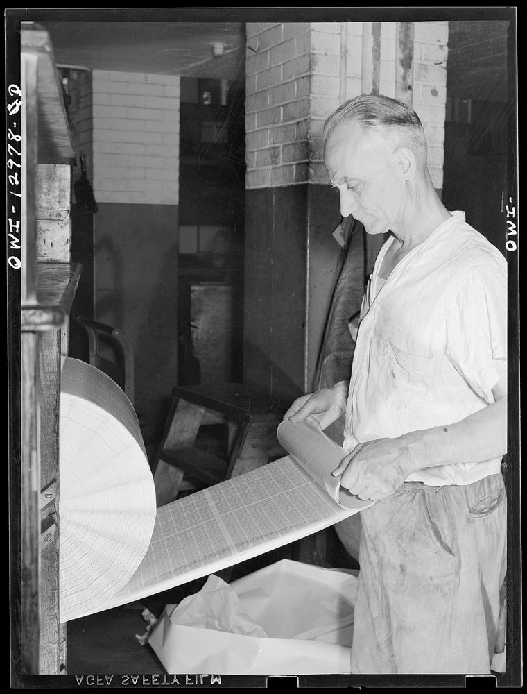 Washington, D.C. Inspecting a postage stamp roll for proper gumming at the United States Bureau of Engraving and Printing.…