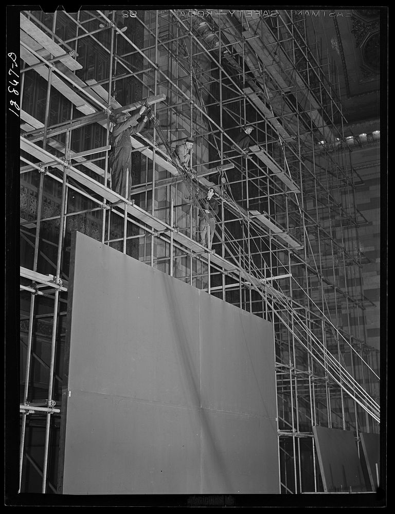 New York, New York. Installing the defense bond sales photomural, prepared by the Farm Security Administration, in the…