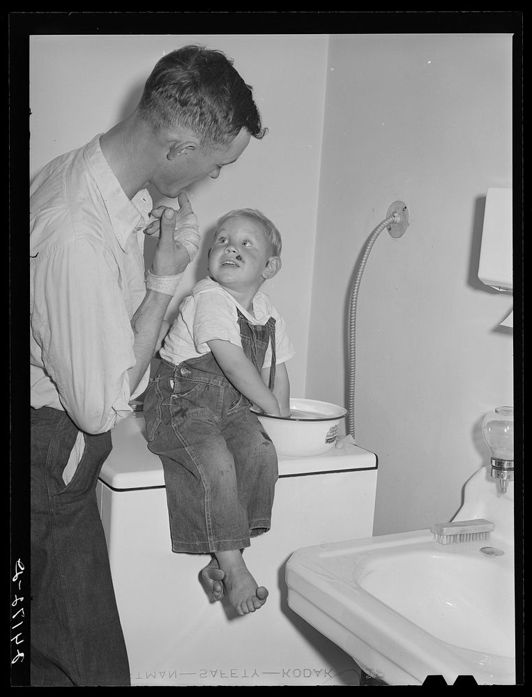 Father watching son being treated at health clinic. Tulare migrant camp  Visalia, California. Sourced from the Library of…