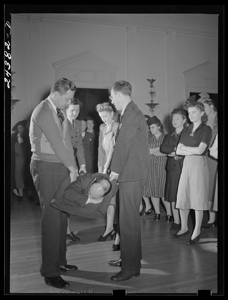 Civilian defense volunteers receiving instruction in proper care for man with spine injury. First aid class. New York City.…