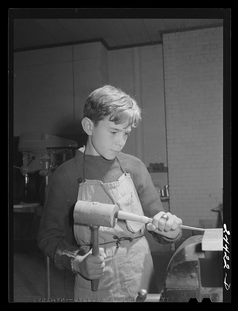Boy grooving wood in shop class at homestead school. Dailey, West Virginia. Sourced from the Library of Congress.