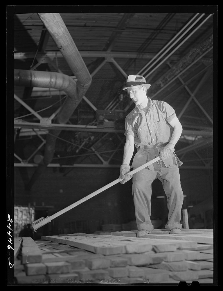 Worker on lumber stacks. Dimension lumber plant. Dailey, West Virginia. Sourced from the Library of Congress.