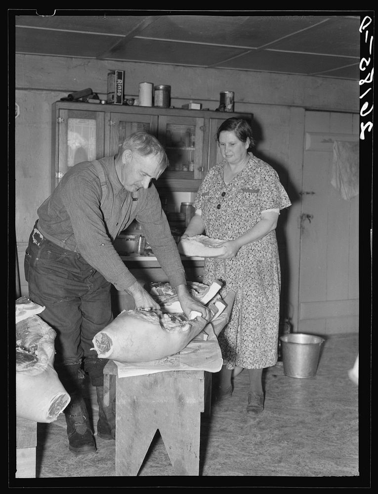 Frank Walker, cutting meat in his farm home near Dalton, New York. Allegany County. Sourced from the Library of Congress.