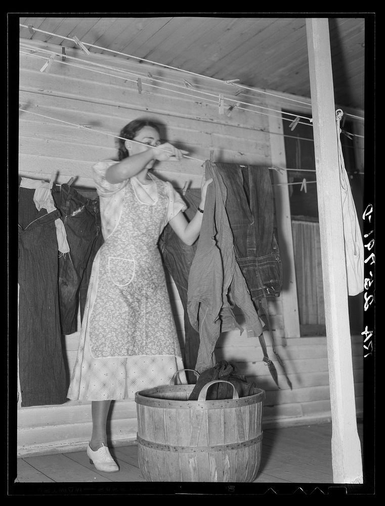 Hired girl taking in the washing. McNally farm, Kirby, Vermont. Sourced from the Library of Congress.