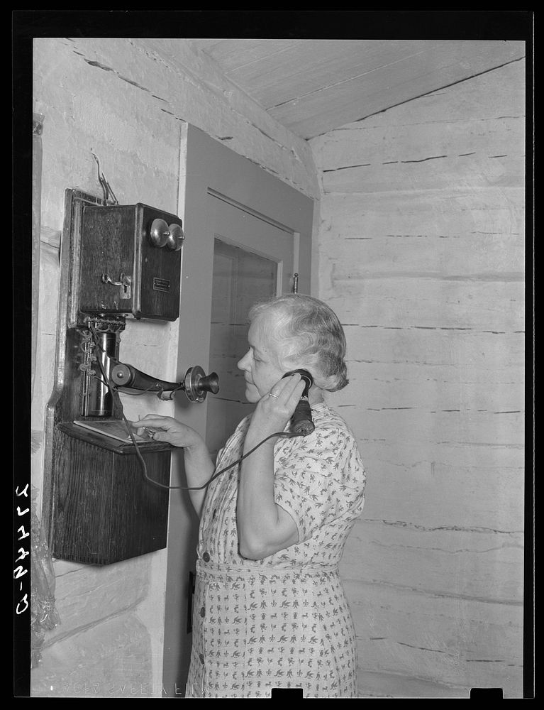 Wife of ranch owner on party line phone. Quarter Circle 'U' Ranch, Montana. Sourced from the Library of Congress.