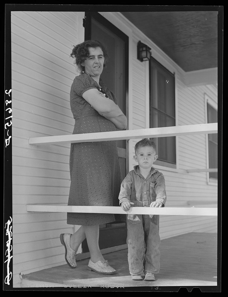 Mrs. Carl Higgins, wife of Mesa County, Colorado, tenant purchase borrower, and son on porch of their farmhouse. Sourced…