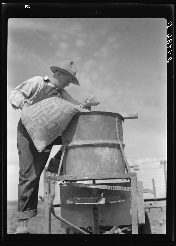 [Untitled photo, possibly related to: Farmer loading spreading device with grasshopper poison. Forsyth, Montana]. Sourced…
