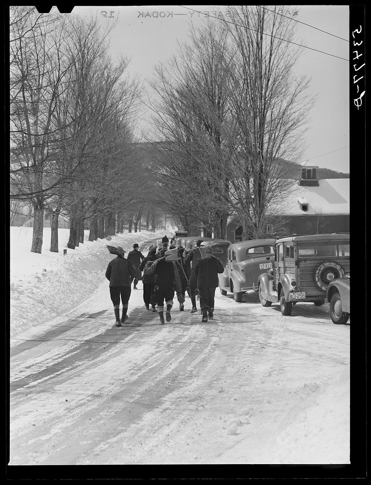 Workmen going down the hill past cars parked for Easter Sunday church services. Sugar Hill, near Franconia, New Hampshire.…