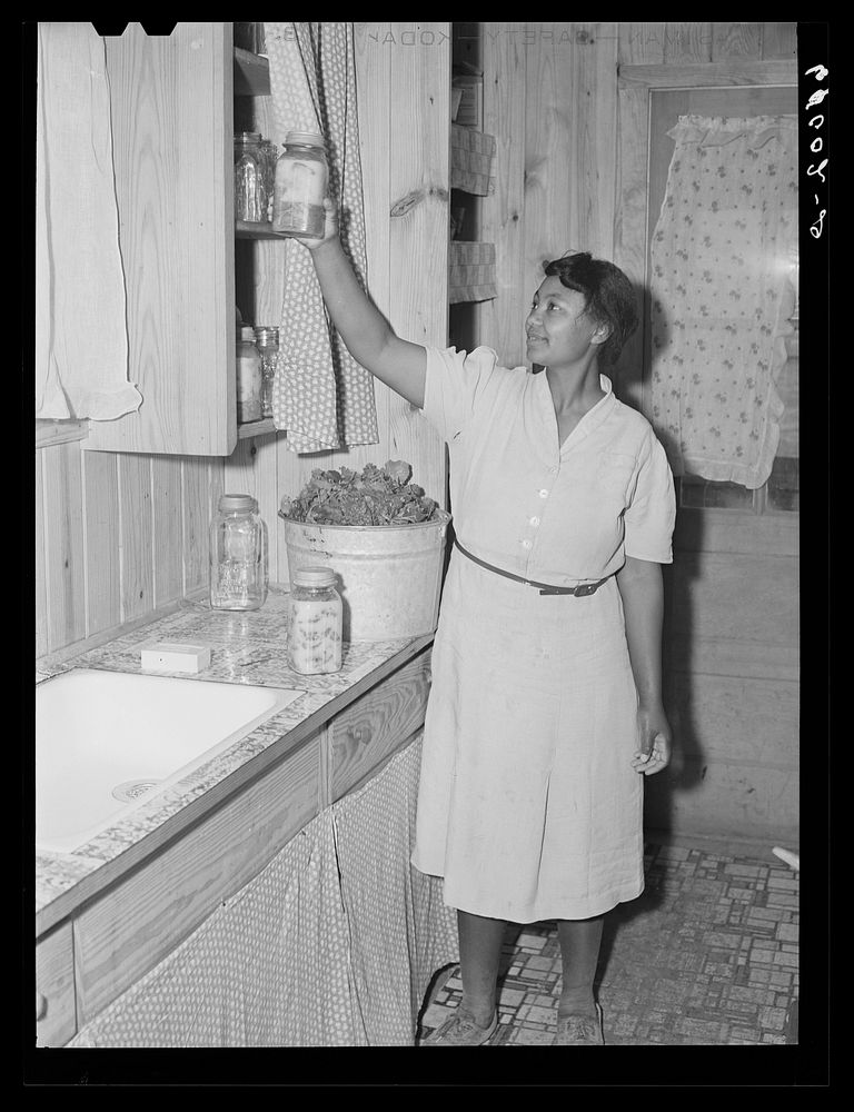 Farmwife at Southeast Missouri project reaching for jar of canned meat. Sourced from the Library of Congress.