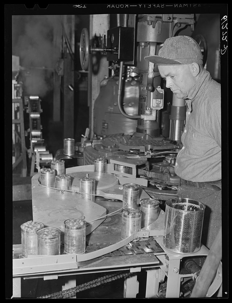Operating machine which seals cans of cherries. Canning plant, Sturgeon Bay, Wisconsin. Sourced from the Library of Congress.