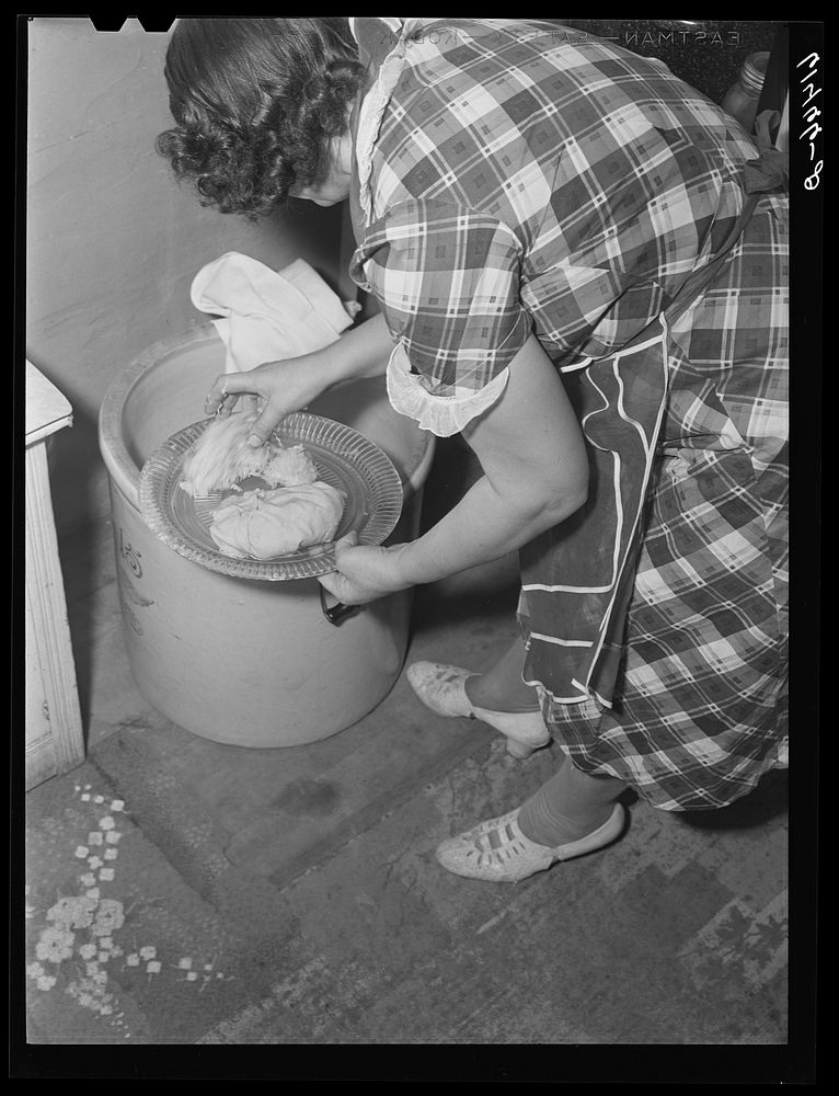 Mrs. Sauer getting sauerkraut out of crock. Cavalier County, North Dakota. Sourced from the Library of Congress.
